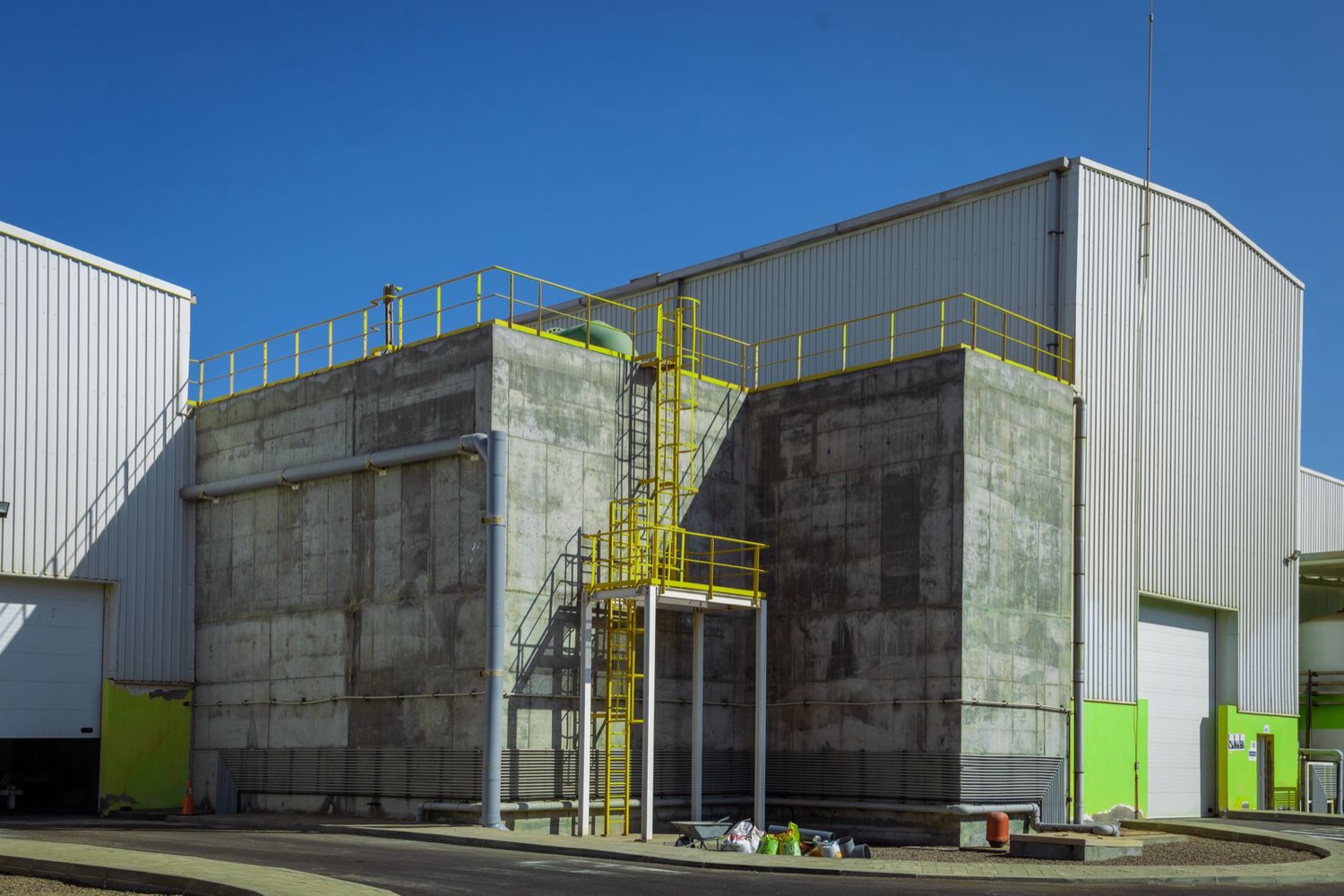 Industrial manufacturing plant exterior with concrete facade and metal-clad buildings